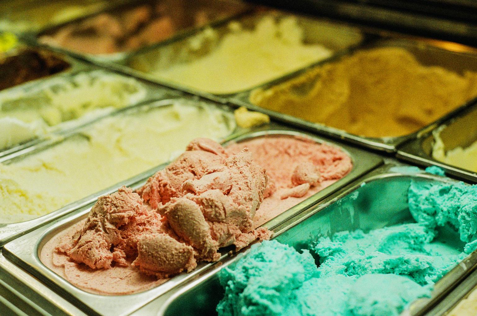 Close-up of various ice cream flavors in a shop freezer, perfect for summer treats.